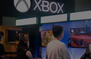Young fairgoers playing Xbox games at a booth during Gamescom 2025 at the Cologne Trade Fair Center in Germany