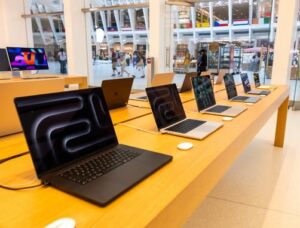 Open MacBook Air laptops displayed in an Apple Store in Manhattan showing Apple products on sale after price increases